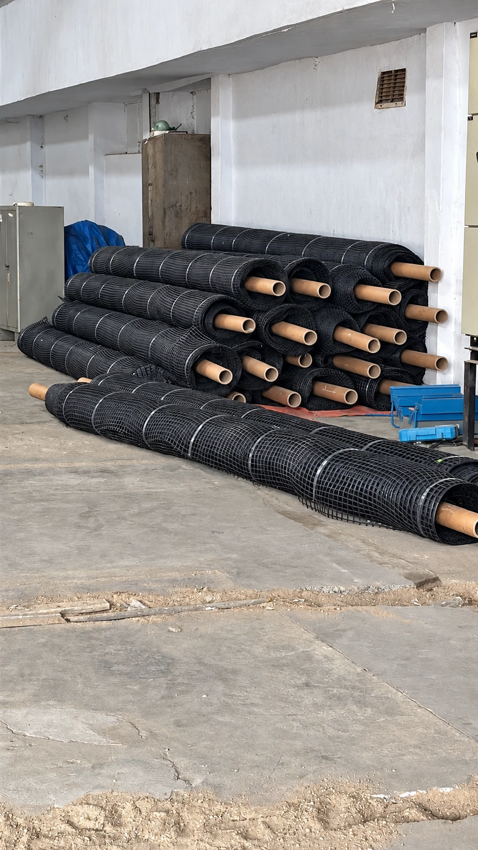 Black geogrid rolls with cardboard cores stored at the Jayatma workplace